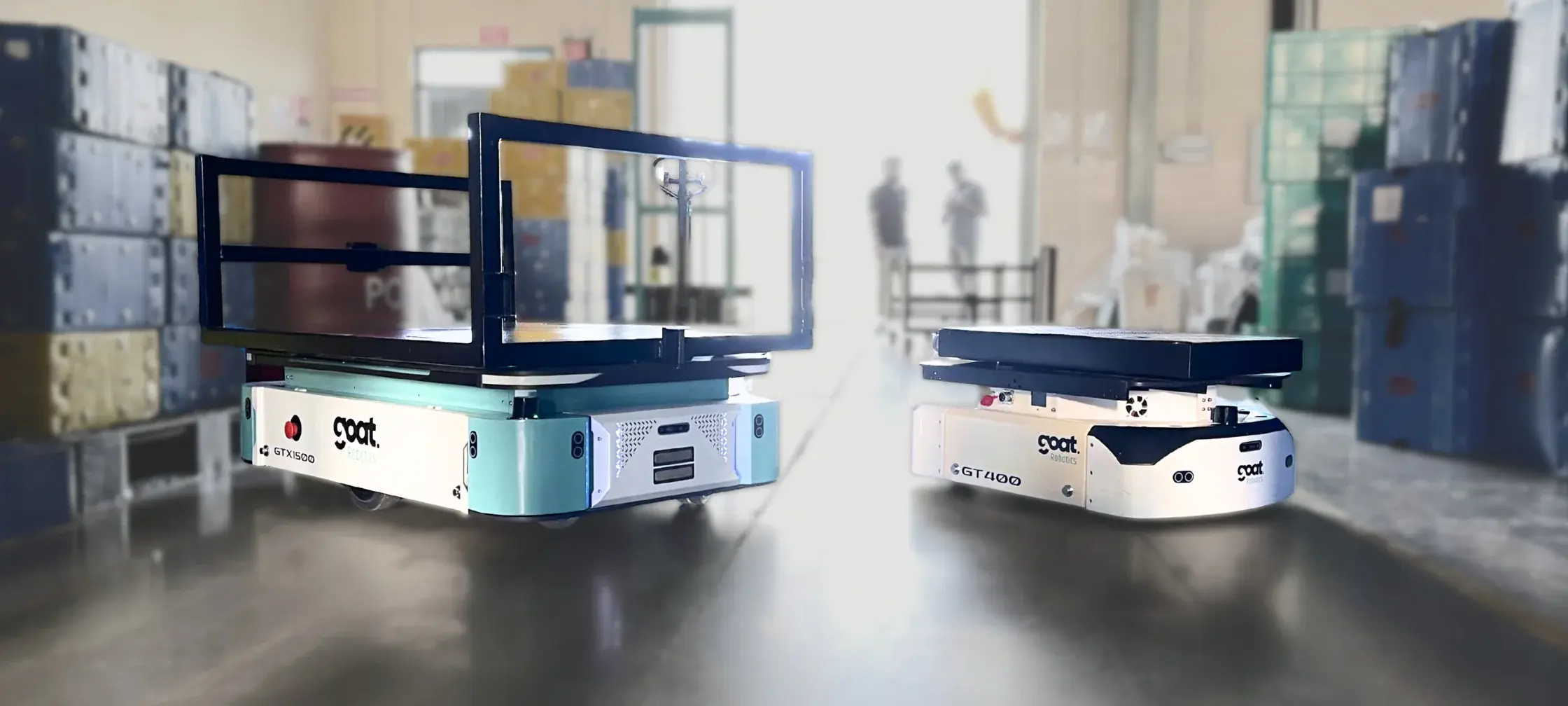 GOAT Robotics GTX-1500 and GT-400 autonomous mobile robots in a warehouse aisle