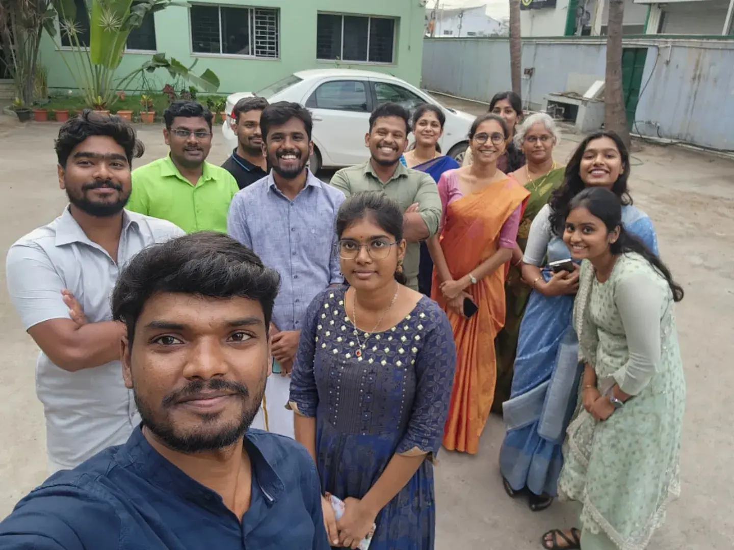 Team selfie in traditional attire outside the office