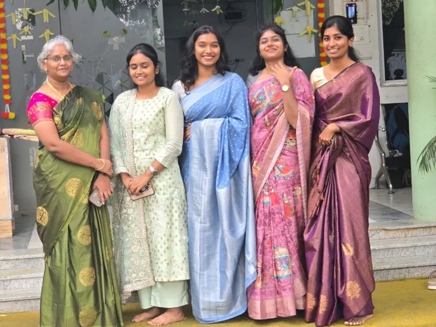 Colleagues in traditional sarees at an office celebration